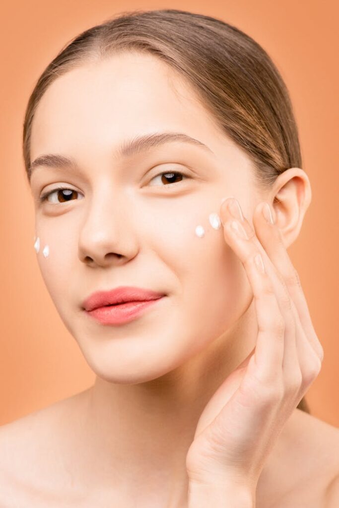 The Art of Drawing Readers In: Your attractive post title goes here Young woman applying facial cream for healthy skincare routine.